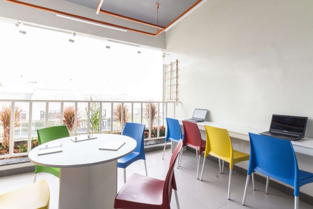Study lounge da MZ School com mesas e cadeiras coloridas